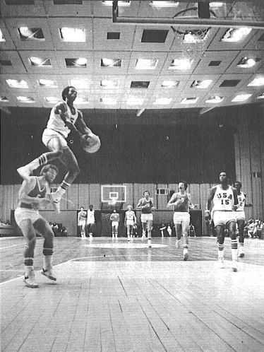 In an international game, High School senior Darrell Griffith casually jumps over a Polish player , who happened to be in his way...